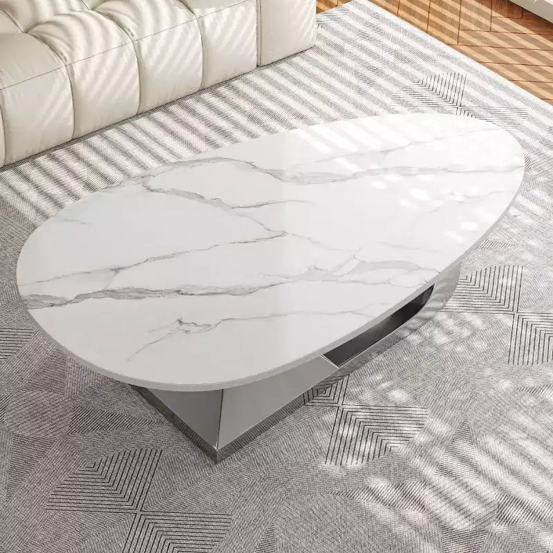Table basse moderne en pierre frittée avec base sculpturale en acier inoxydable, en forme de galet imitation marbre